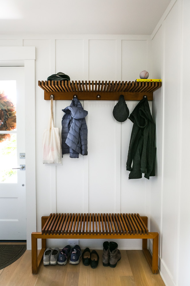 Inspiration for a transitional mudroom in San Francisco with white walls, medium hardwood floors, a single front door, a white front door and brown floor.