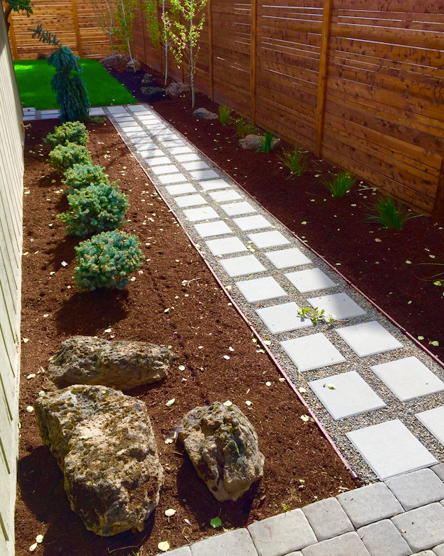 This is an example of a mid-sized midcentury side yard partial sun garden in Other with concrete pavers.