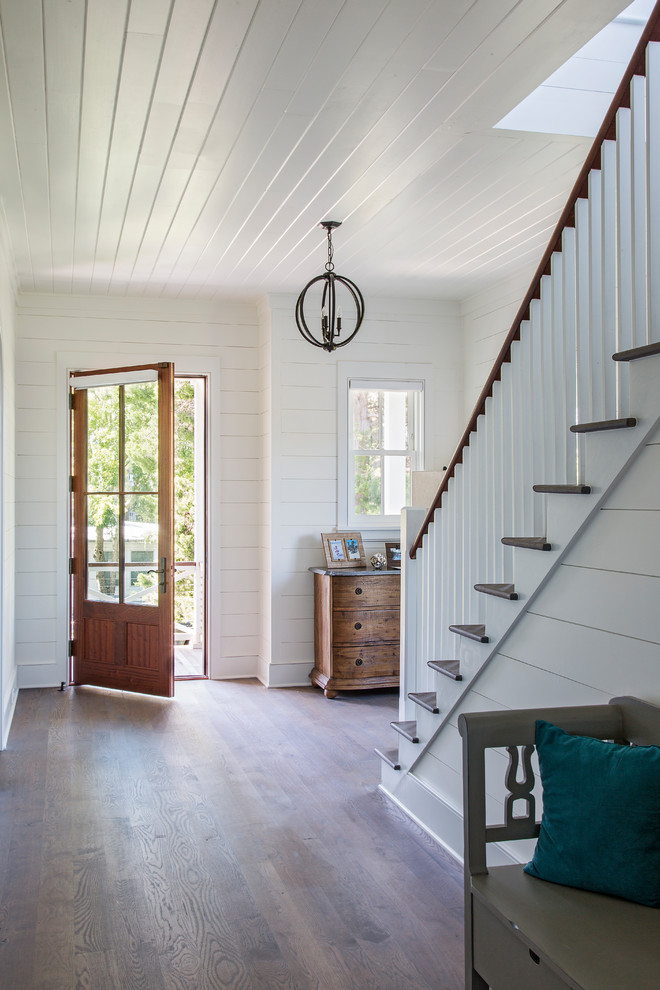 Design ideas for a country entry hall in Charleston with white walls, medium hardwood floors, a single front door, a glass front door and brown floor.