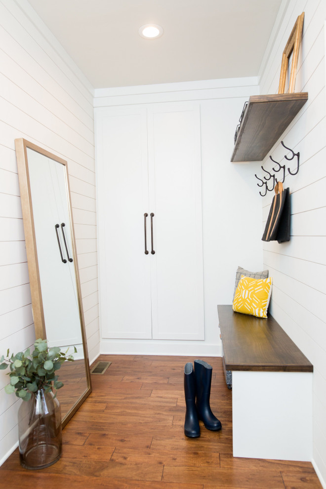 Photo of a mid-sized transitional mudroom in Philadelphia with white walls, medium hardwood floors and brown floor.