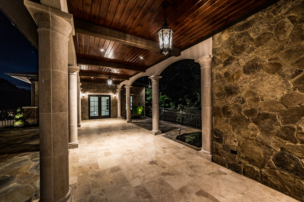 Example of a mid-sized mountain style travertine floor and beige floor foyer design with brown walls and a glass front door