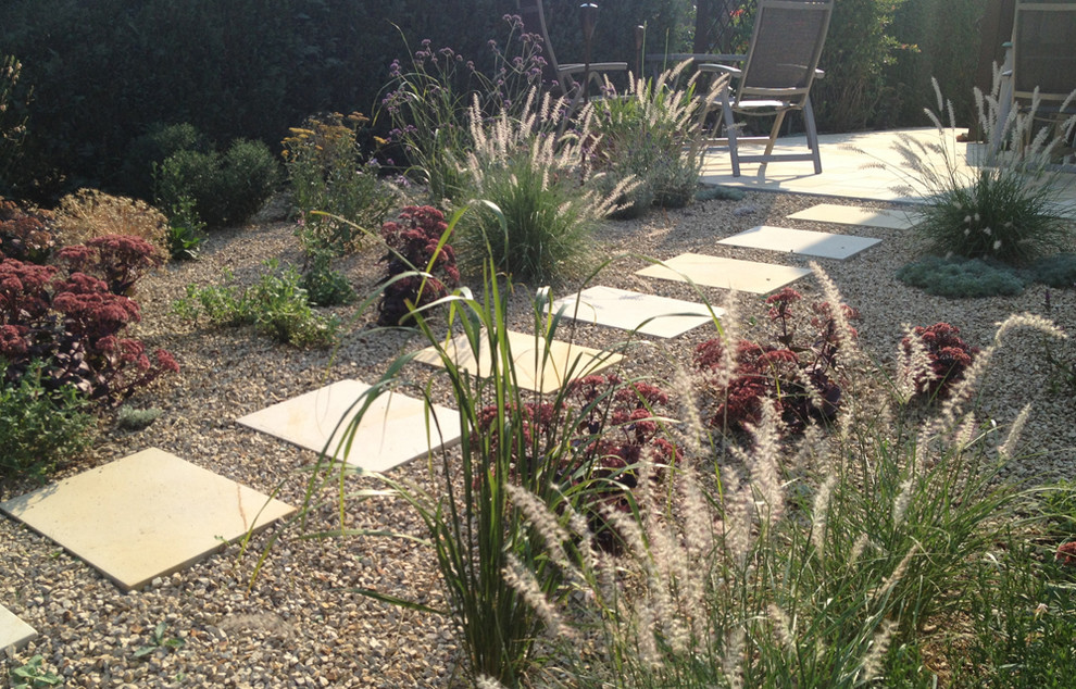 Kleiner Moderner Gartenweg im Sommer, neben dem Haus mit direkter Sonneneinstrahlung und Natursteinplatten in Dresden