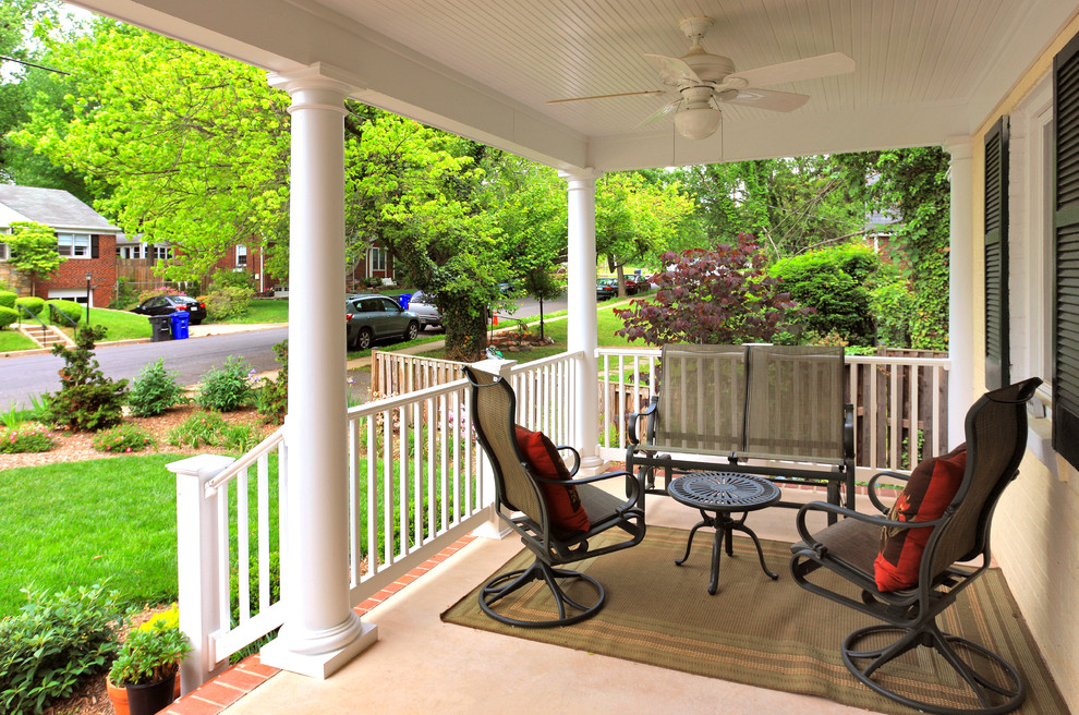 Mid-sized traditional front yard verandah in DC Metro with brick pavers and a roof extension.