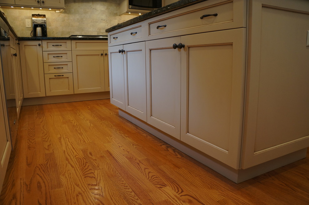 Transitional eat-in kitchen photo in Boston with an undermount sink, recessed-panel cabinets, white cabinets, granite countertops and an island