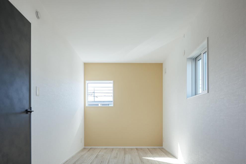 Cette image montre une petite chambre neutre avec un mur blanc, un sol beige, un plafond en papier peint et du papier peint.
