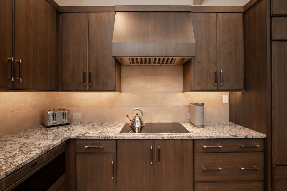 Modern inredning av ett mellanstort brun brunt kök, med en undermonterad diskho, släta luckor, skåp i mörkt trä, granitbänkskiva, beige stänkskydd, stänkskydd i porslinskakel, integrerade vitvaror, ljust trägolv, en köksö och brunt golv
