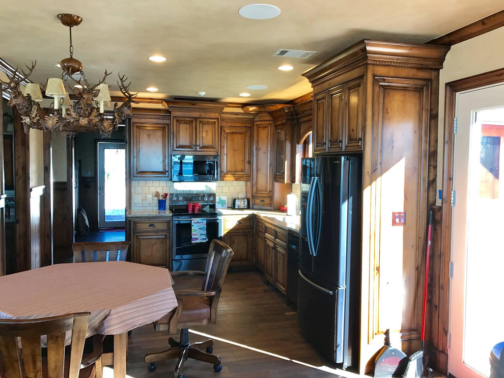This is an example of a mid-sized traditional l-shaped eat-in kitchen in Dallas with raised-panel cabinets, brown cabinets and granite benchtops.