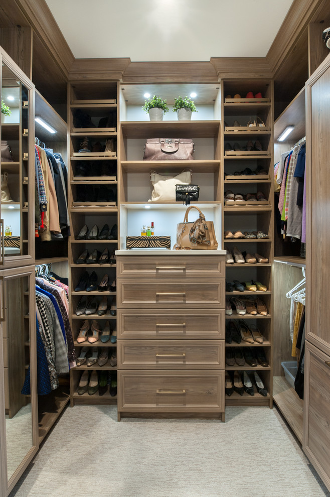 This is an example of a mid-sized transitional gender-neutral walk-in wardrobe in Detroit with recessed-panel cabinets, blue cabinets, carpet and beige floor.
