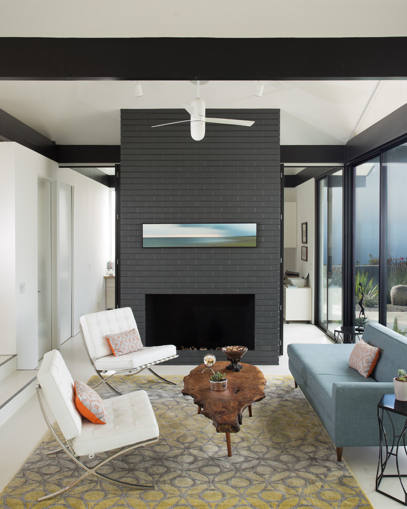This is an example of a midcentury living room in Los Angeles with a standard fireplace and a brick fireplace surround.