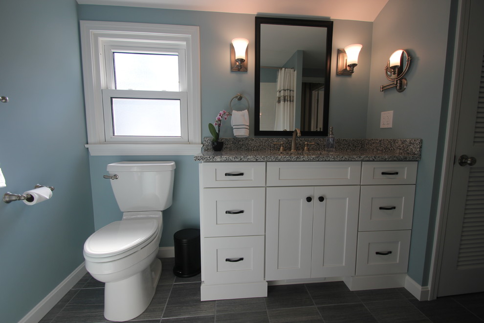 Mid-sized traditional bathroom in Cleveland with shaker cabinets, white cabinets, blue walls, an undermount sink, granite benchtops, an alcove tub, a shower/bathtub combo, white tile, subway tile, porcelain floors and grey floor.