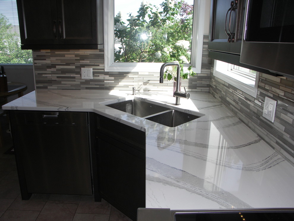 Mid-sized transitional u-shaped porcelain tile open concept kitchen photo in Edmonton with an undermount sink, recessed-panel cabinets, dark wood cabinets, quartzite countertops, multicolored backsplash, matchstick tile backsplash, white appliances and two islands