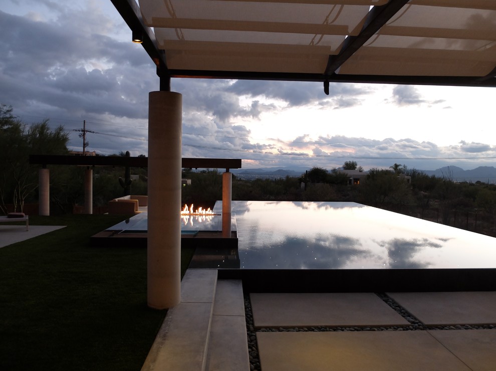 Photo of a large contemporary backyard rectangular infinity pool in Phoenix with a hot tub and concrete pavers.