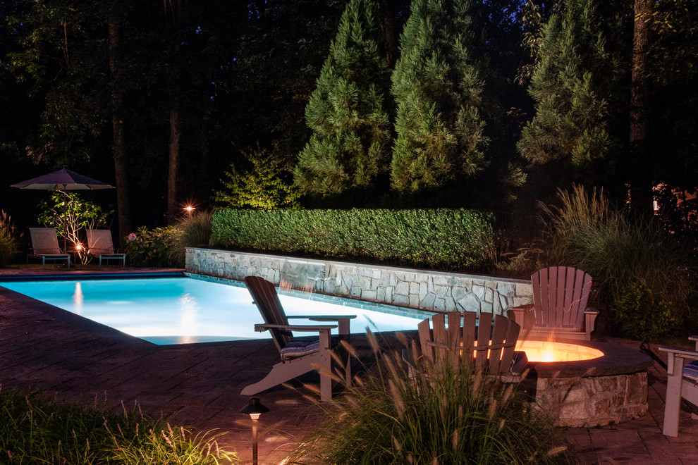Mid-sized eclectic backyard rectangular lap pool in DC Metro with a water feature and concrete pavers.