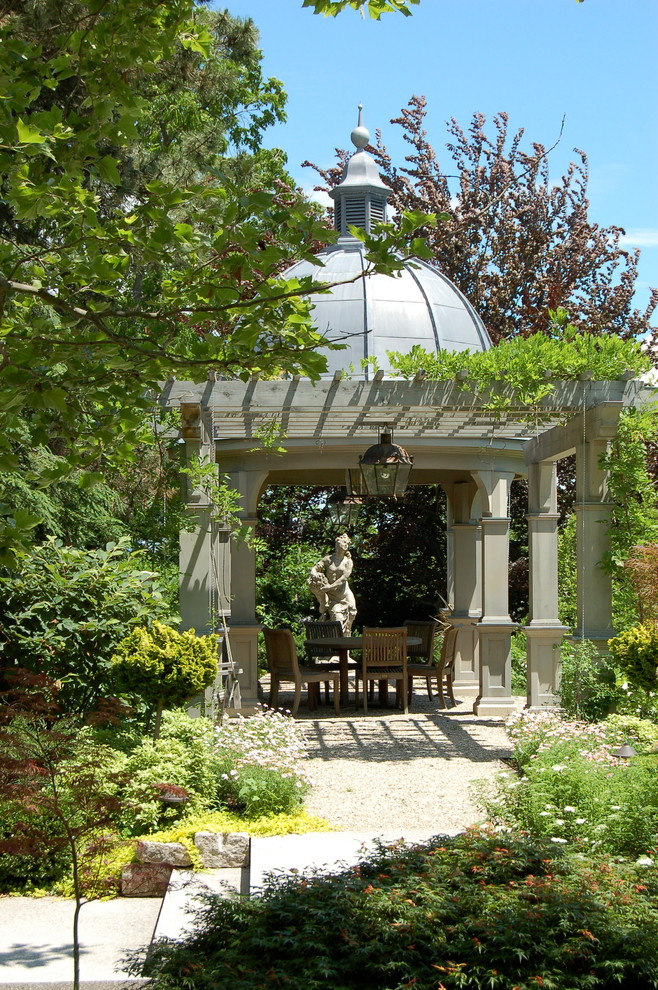 Inspiration for a large traditional courtyard patio in Boston with a pergola and gravel.
