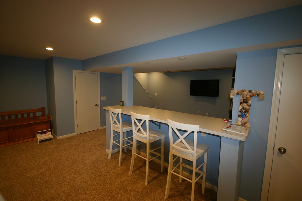 This is an example of a mid-sized traditional fully buried basement in Milwaukee with blue walls and carpet.