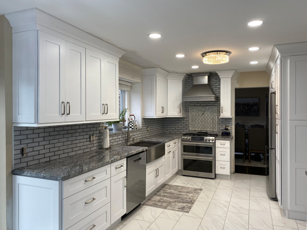 Photo of a mid-sized contemporary u-shaped eat-in kitchen in Detroit with a farmhouse sink, shaker cabinets, white cabinets, granite benchtops, grey splashback, subway tile splashback, marble floors, no island, white floor and grey benchtop.