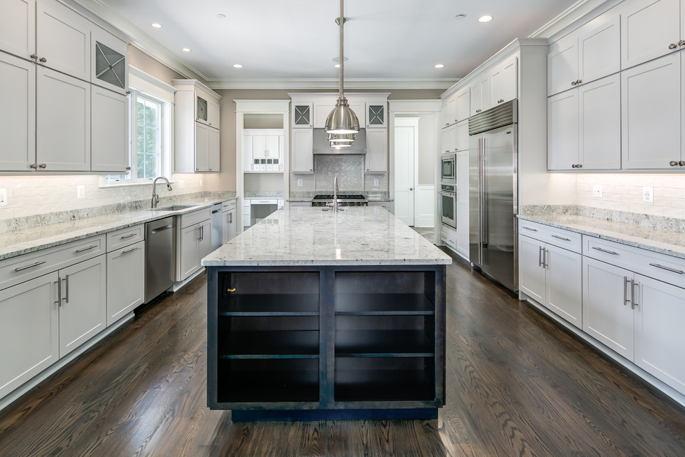 Large transitional u-shaped dark wood floor enclosed kitchen photo in DC Metro with a drop-in sink, recessed-panel cabinets, white cabinets, granite countertops, white backsplash, subway tile backsplash, stainless steel appliances and an island