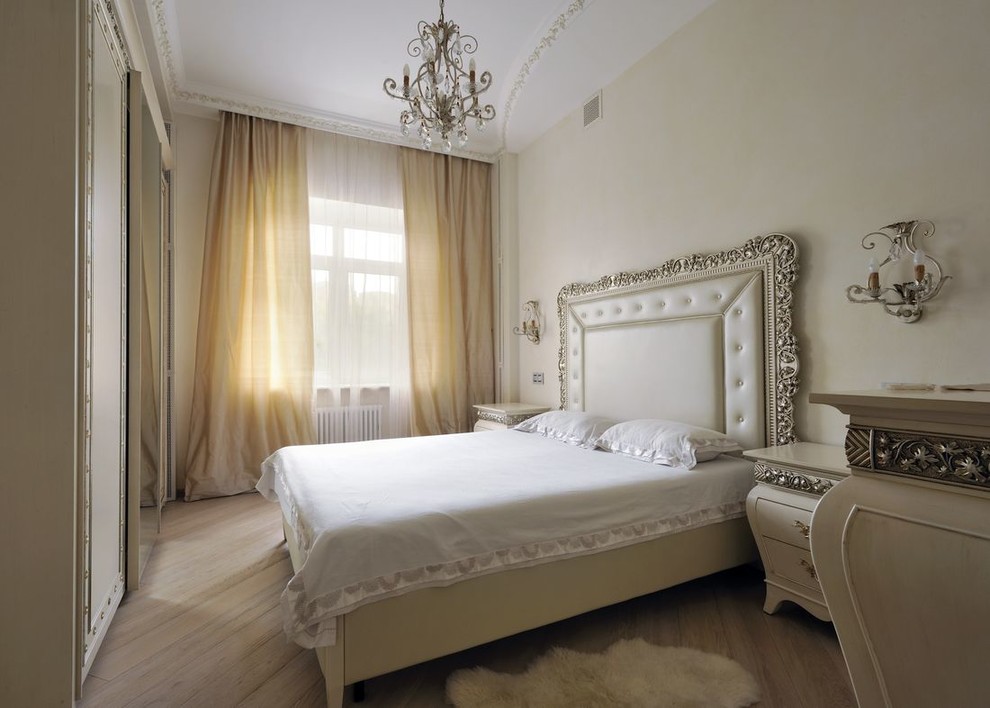Mid-sized traditional master bedroom in Moscow with beige walls and medium hardwood floors.
