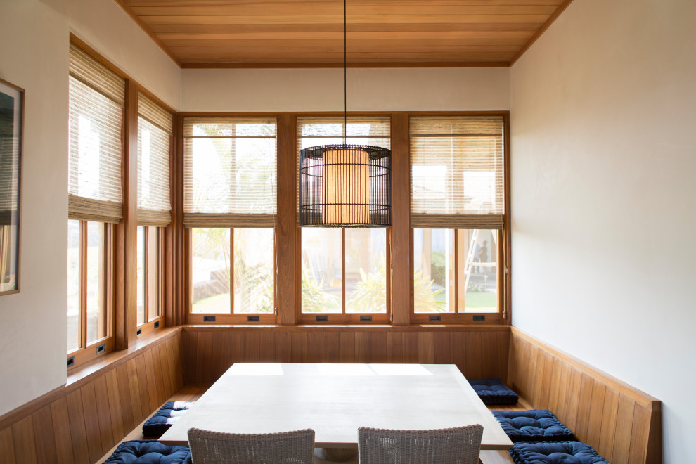 Réalisation d'une salle à manger marine avec une banquette d'angle, un mur blanc et un plafond en bois.