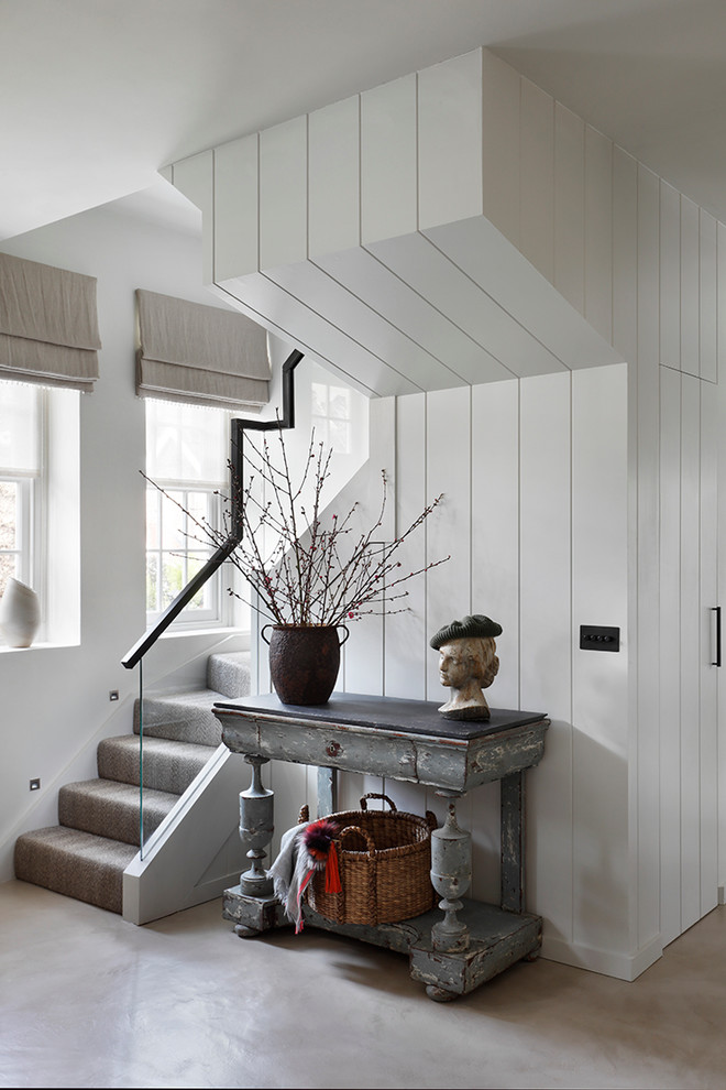 Photo of a transitional foyer in London with white walls.