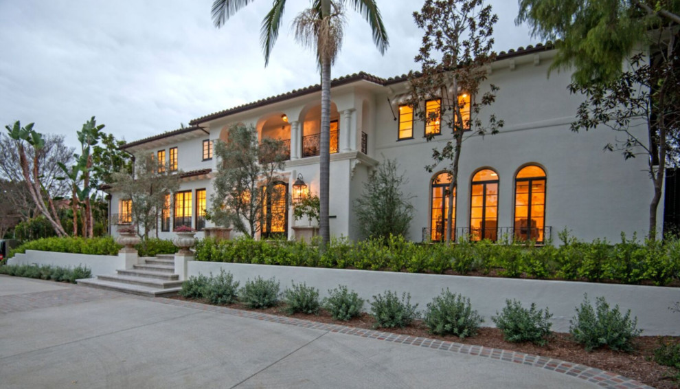 Photo of a large mediterranean two-storey white house exterior in Los Angeles with a gable roof and a shingle roof.