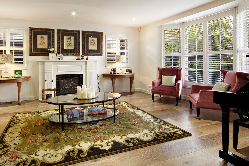 Inspiration for a traditional living room in Melbourne with white walls, medium hardwood floors and a standard fireplace.