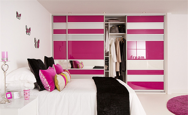 Photo of a small modern kids' room for girls in Miami with pink walls and light hardwood floors.
