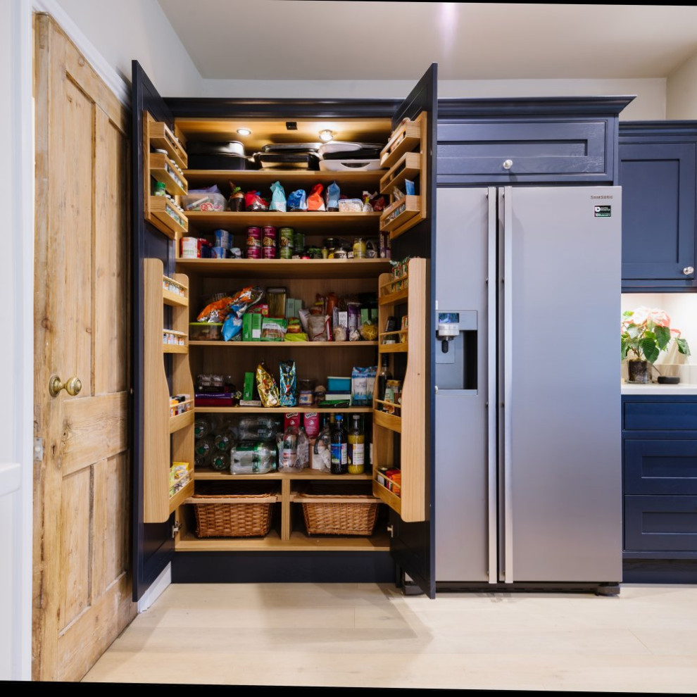 Inspiration for a mid-sized u-shaped eat-in kitchen in Sussex with shaker cabinets, blue cabinets, wood benchtops, multi-coloured splashback, mirror splashback, stainless steel appliances, light hardwood floors, with island, brown floor and brown benchtop.