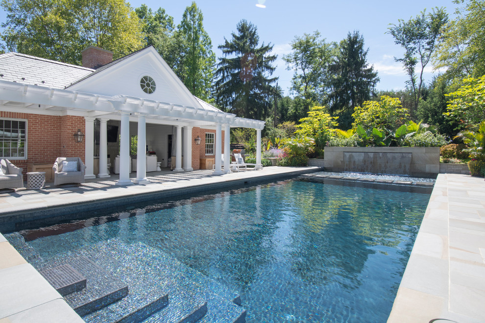 Pool - large traditional backyard stone pool idea in Cleveland