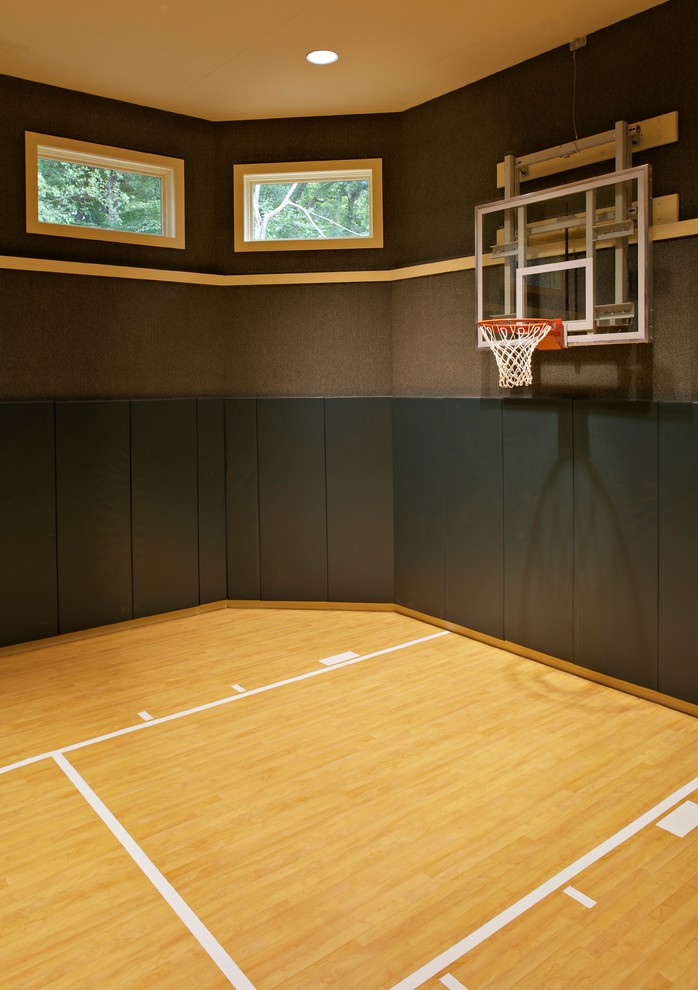 This is an example of a large traditional indoor sport court in Chicago with black walls and light hardwood floors.