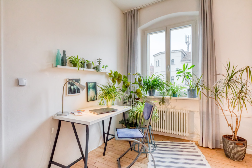 This is an example of a small scandinavian craft room in Berlin with a freestanding desk.