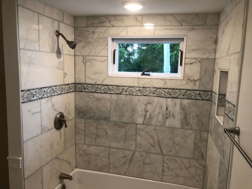 This is an example of a mid-sized traditional kids bathroom in Boston with raised-panel cabinets, grey cabinets, an alcove tub, a shower/bathtub combo, gray tile, travertine, marble benchtops, white benchtops, a single vanity and a freestanding vanity.