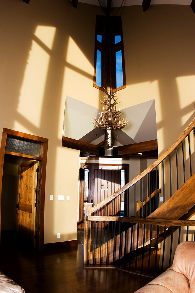 Example of a large mountain style dark wood floor front door design in Edmonton with beige walls and a medium wood front door