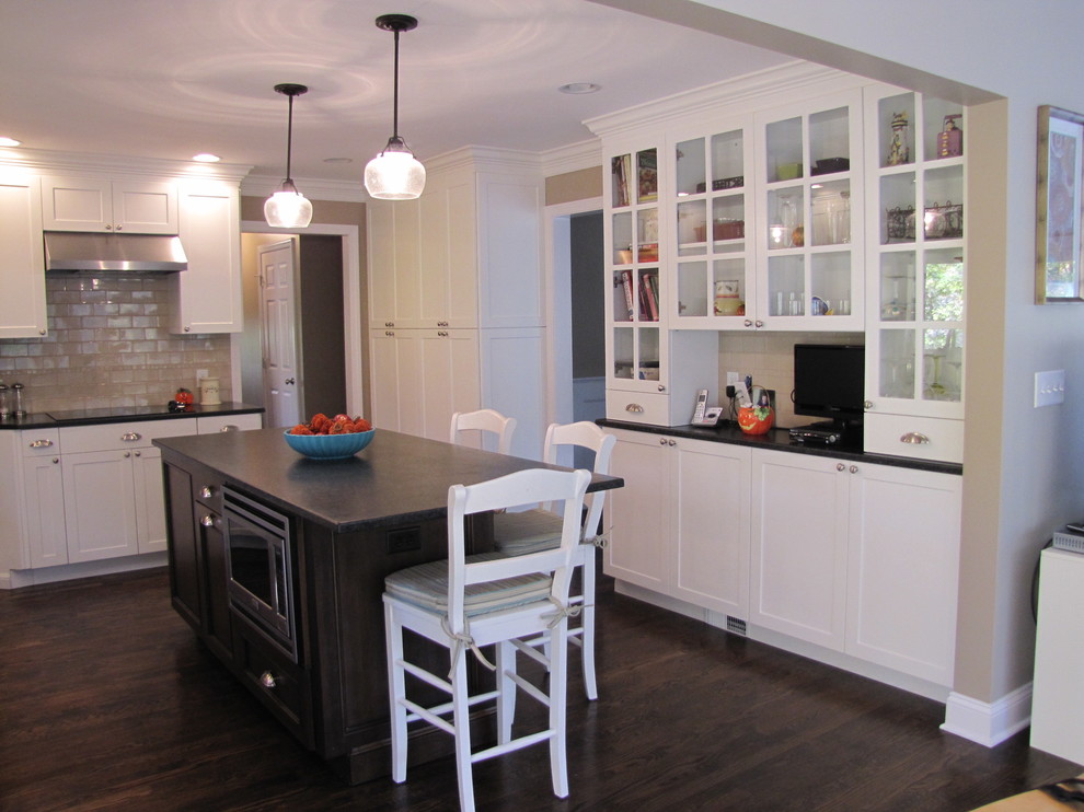 Example of a mid-sized transitional u-shaped dark wood floor eat-in kitchen design in New York with an undermount sink, shaker cabinets, granite countertops, beige backsplash, stainless steel appliances, beige cabinets, porcelain backsplash and an island