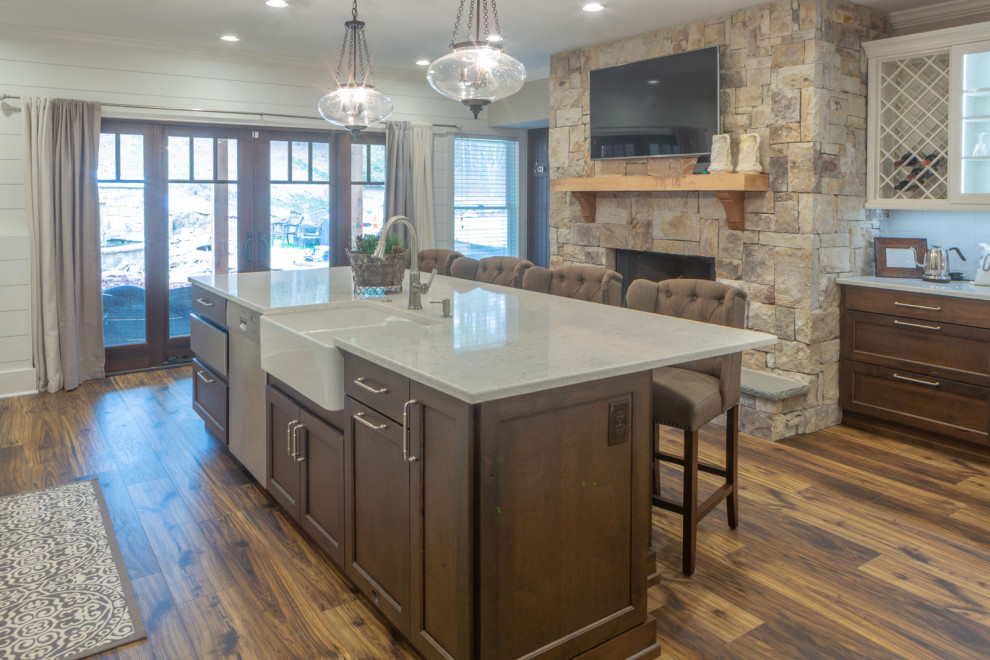 Foto de cocina clásica grande abierta con salpicadero blanco, electrodomésticos de acero inoxidable, suelo de madera en tonos medios, una isla y encimeras blancas