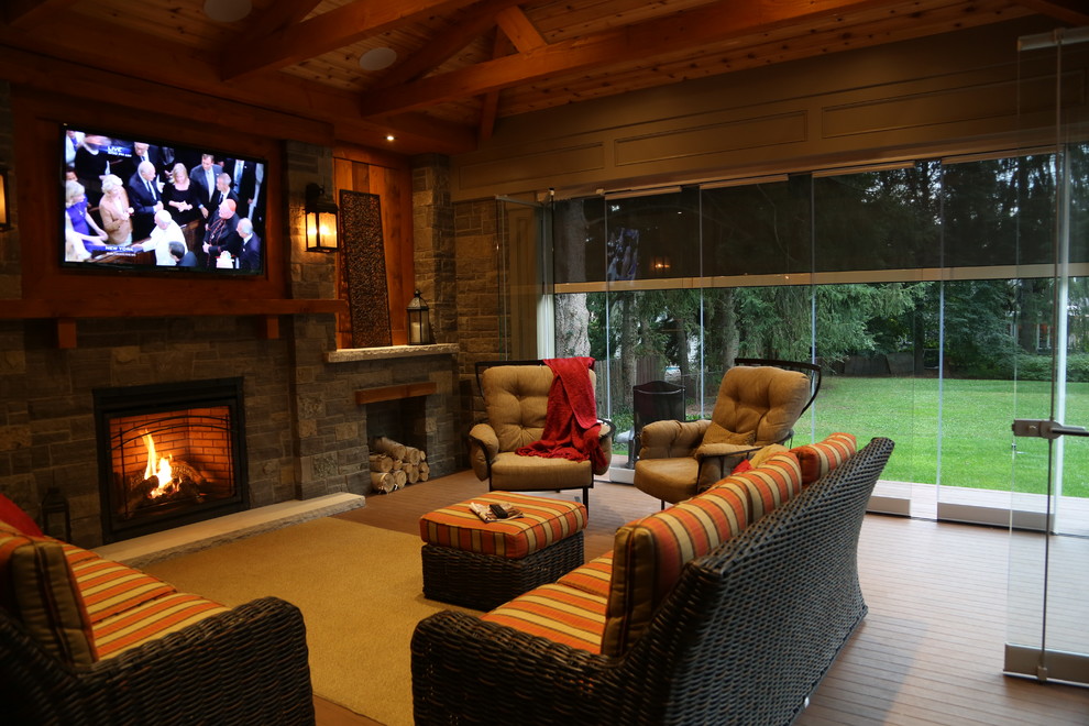 Photo of a transitional backyard verandah in Toronto with a fire feature, decking and a roof extension.