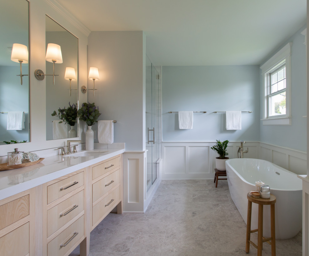 Immagine di una grande stanza da bagno padronale classica con ante lisce, ante in legno chiaro, top in marmo, due lavabi e mobile bagno incassato