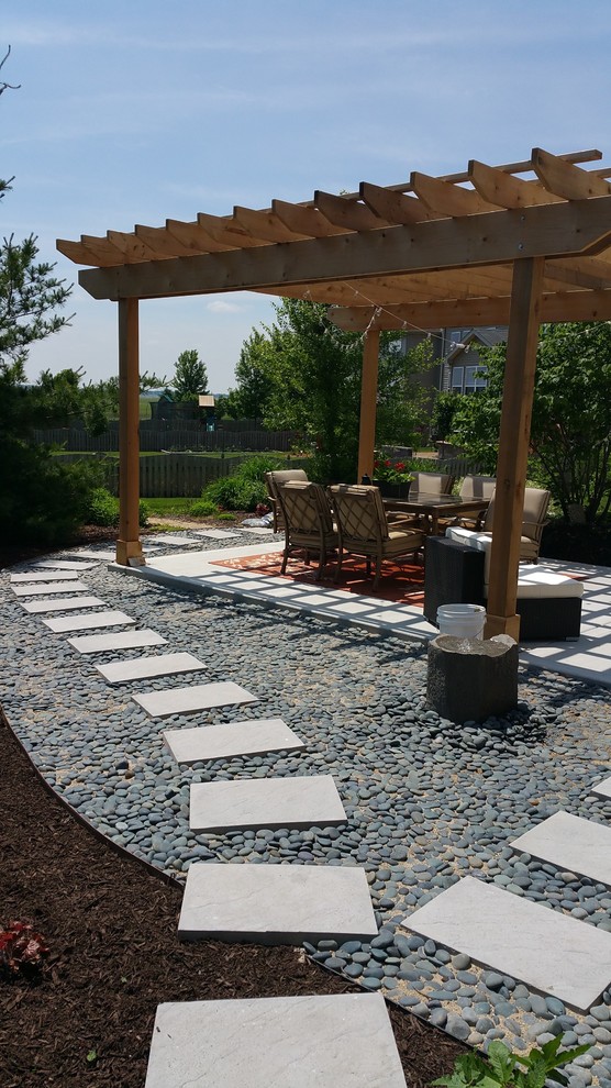 Photo of a mid-sized contemporary backyard patio in Chicago with a water feature, concrete slab and a pergola.