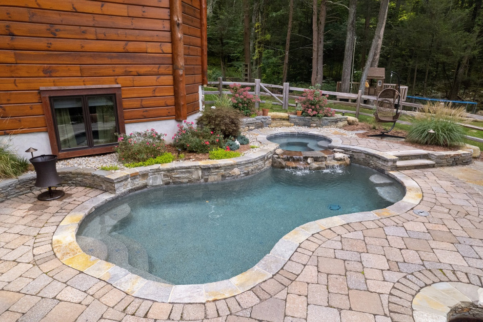 Large classic back custom shaped hot tub in Bridgeport with concrete paving.