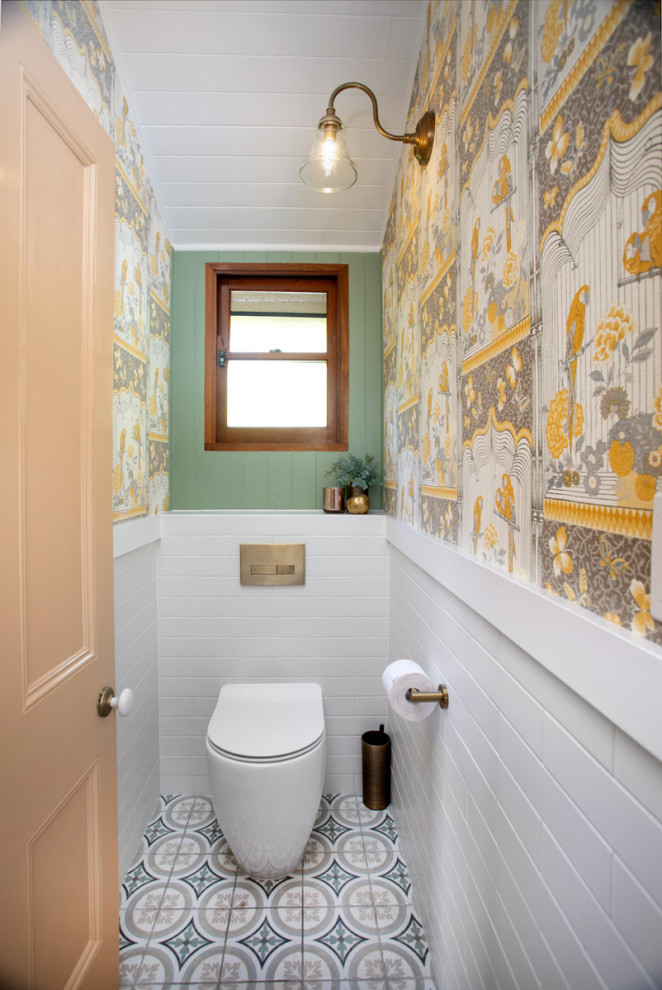 Klassisches Badezimmer mit Wandtoilette mit Spülkasten, farbigen Fliesen, Metrofliesen, grüner Wandfarbe, Porzellan-Bodenfliesen, buntem Boden, WC-Raum und Tapetenwänden