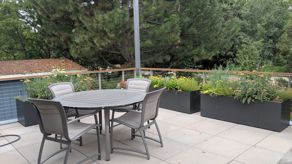 This is an example of a mid-sized contemporary rooftop full sun xeriscape in Denver with with flowerbed.
