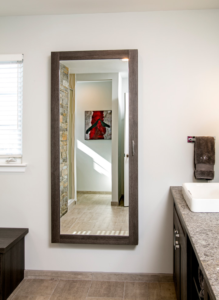 This is an example of a mid-sized modern master bathroom in Philadelphia with furniture-like cabinets, brown cabinets, a double shower, a two-piece toilet, beige tile, porcelain tile, beige walls, porcelain floors, an undermount sink and limestone benchtops.