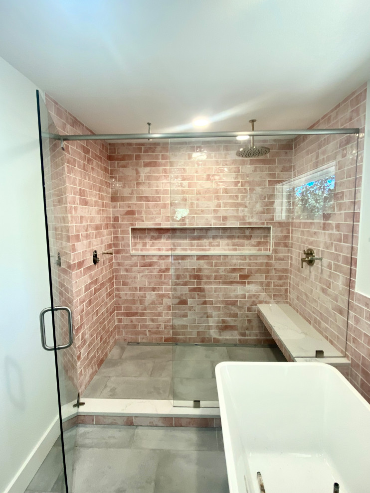 Пример оригинального дизайна: главная ванная комната в стиле фьюжн с отдельно стоящей ванной, двойным душем, красной плиткой и душем с распашными дверями