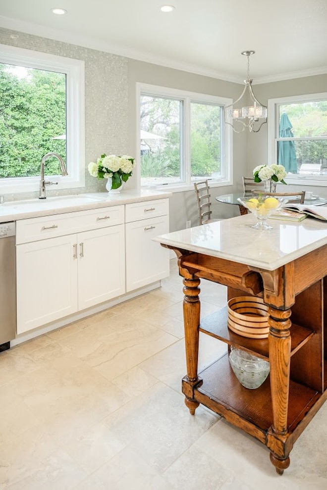Example of a large transitional u-shaped limestone floor eat-in kitchen design with an undermount sink, shaker cabinets, white cabinets, marble countertops, metallic backsplash, mosaic tile backsplash, stainless steel appliances and an island