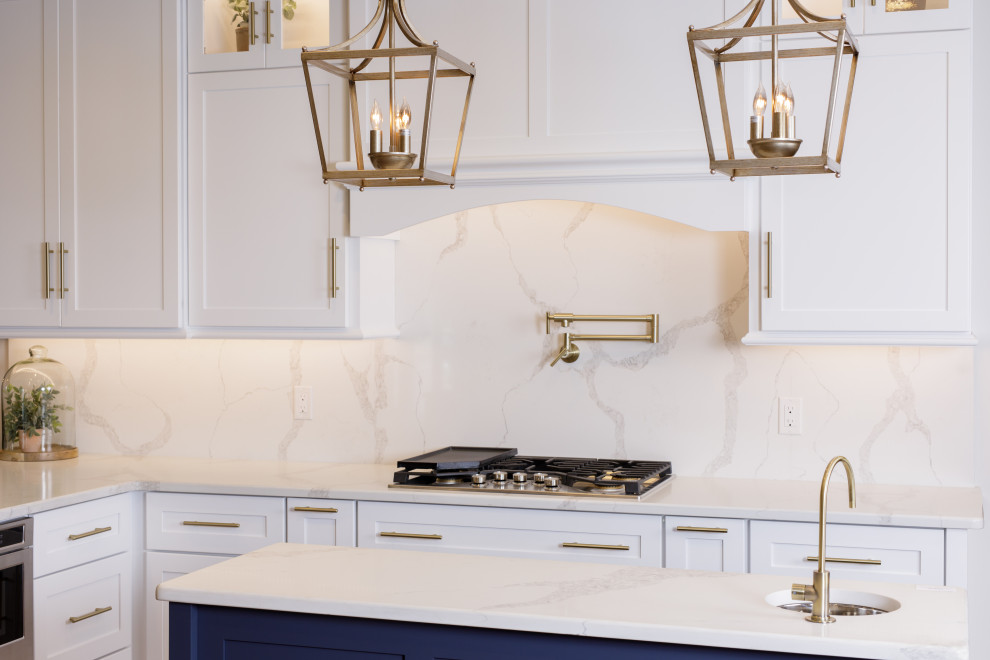Kitchen - kitchen idea with an undermount sink, white cabinets, quartz countertops, white backsplash, quartz backsplash, stainless steel appliances, an island and white countertops