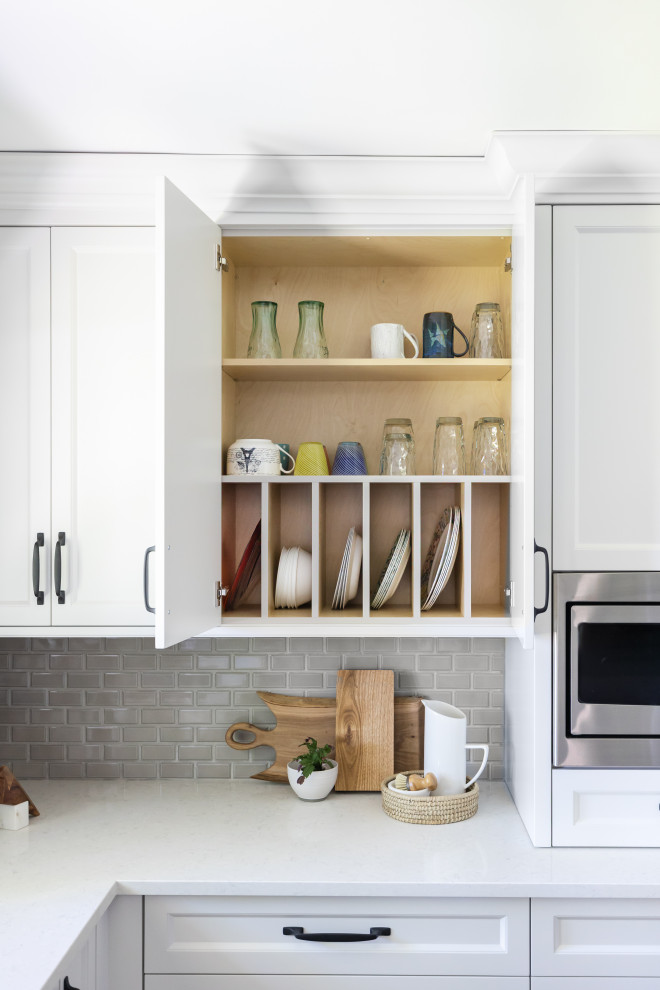 Enclosed kitchen - mid-sized transitional l-shaped medium tone wood floor and brown floor enclosed kitchen idea in Toronto with a double-bowl sink, recessed-panel cabinets, white cabinets, quartz countertops, gray backsplash, porcelain backsplash, stainless steel appliances, an island and gray countertops
