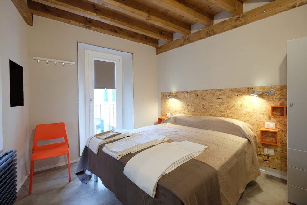 Photo of a contemporary master bedroom in Turin with beige walls, porcelain floors and grey floor.