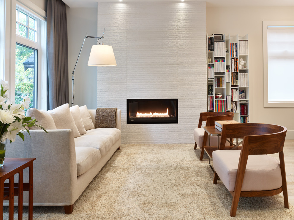 This is an example of a small contemporary open concept living room in Vancouver with a library, beige walls, carpet, a ribbon fireplace and no tv.