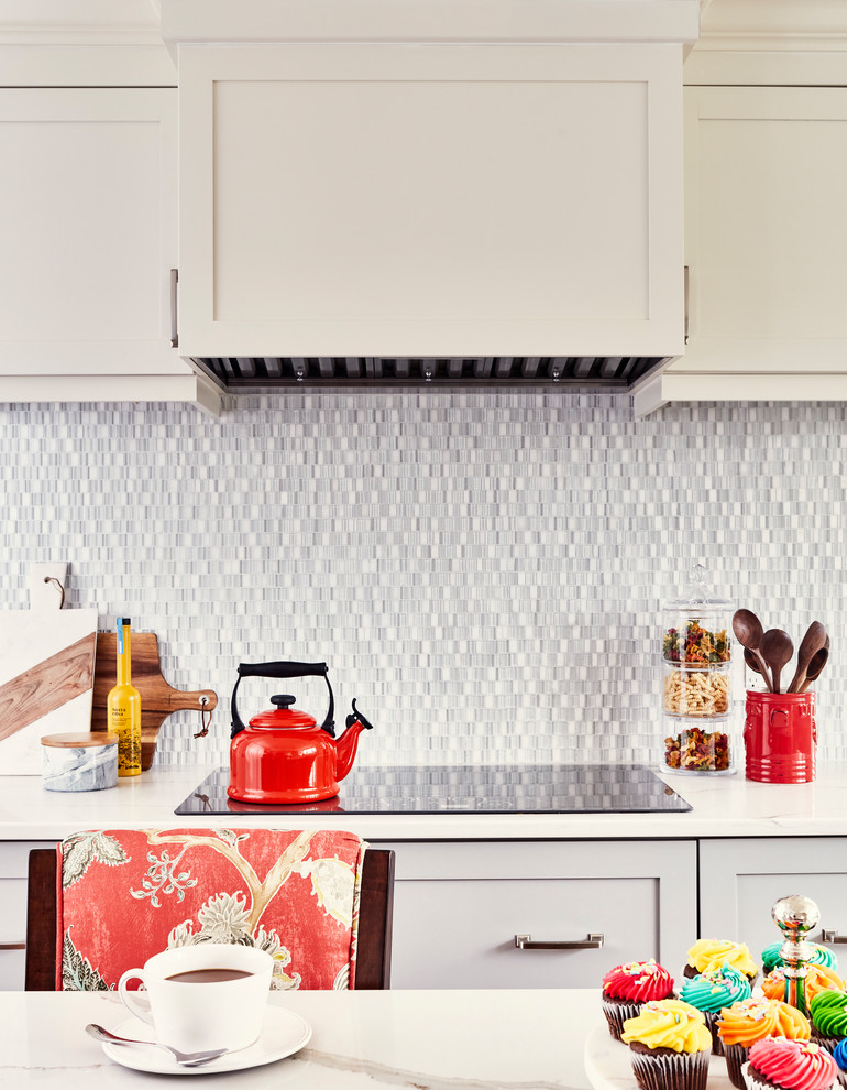 Mid-sized transitional u-shaped medium tone wood floor and brown floor enclosed kitchen photo with an undermount sink, shaker cabinets, gray cabinets, quartz countertops, multicolored backsplash, glass sheet backsplash, stainless steel appliances, an island and white countertops