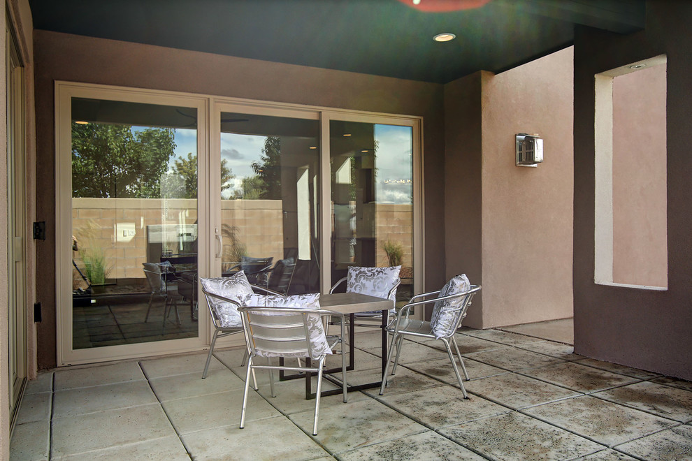 This is an example of a mid-sized contemporary courtyard patio in Albuquerque with tile and no cover.